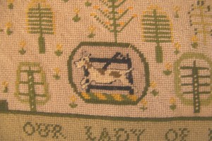 Detail showing the Todhunter family crest: a hound and a gate